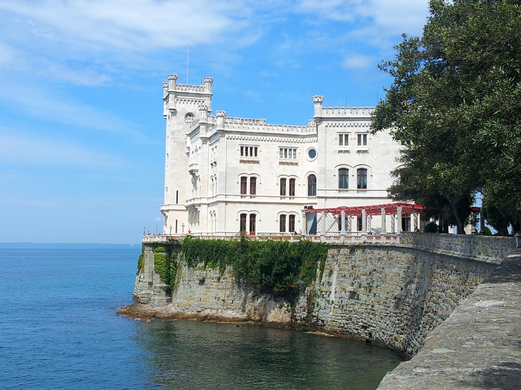 White Miramare Castle rising from its sea wall above the blue Gulf of Trieste
